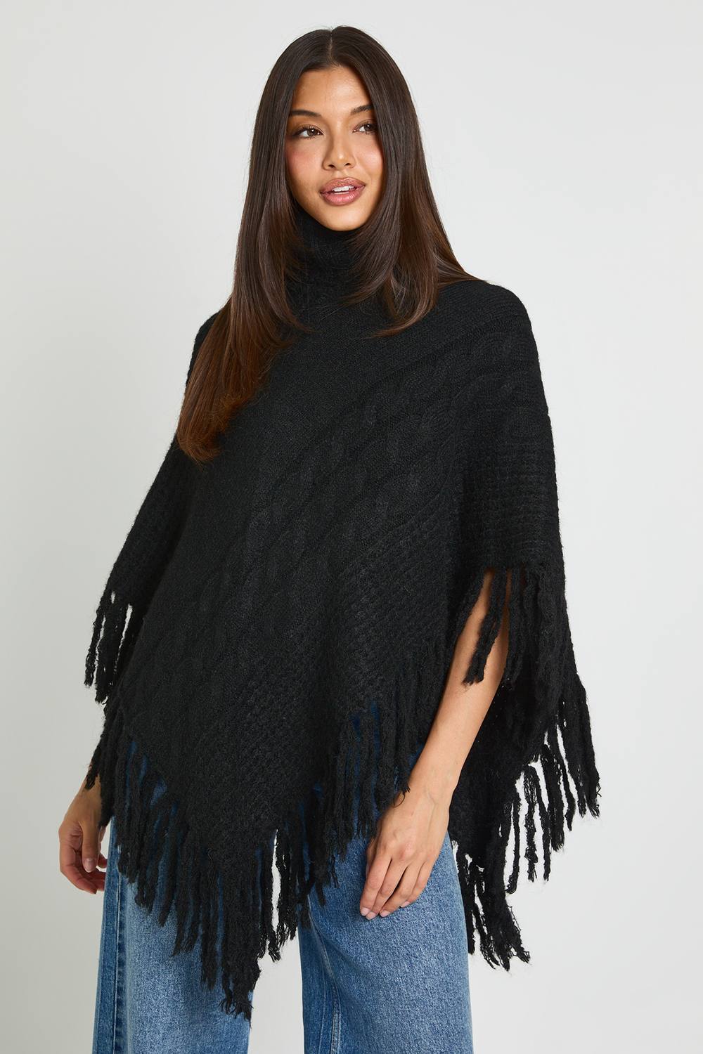 boohoo Women's Roll Neck Cable Detail Tassel Hem Cape in Black by boohoo